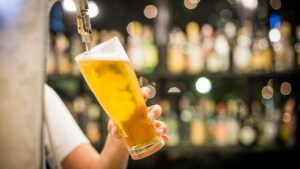 Pouring beer in a beer glass in hand
